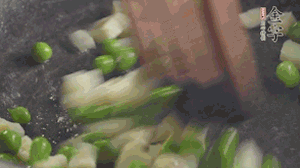 鍋中油7成熱時(shí)，入青豆、筍丁翻炒，然后加糯米飯加鹽均勻翻炒。