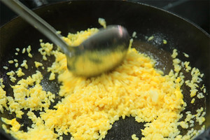 大火加熱炒鍋，再入油，燒到四至五成熱時倒入雞蛋液，在未凝結(jié)之前，加米飯煸炒，不停翻炒并用鍋鏟將成塊的米飯碾開、撥散。