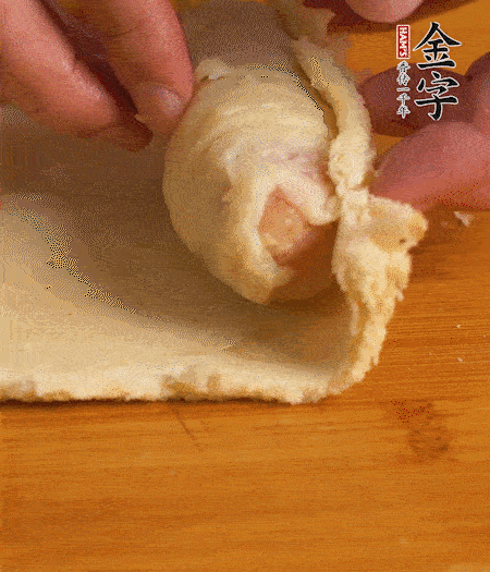 吐司卷起香腸，吐司尾端涂抹少許全蛋液，卷好的吐司表面蘸上蛋液，在裹上一層面包糠，送入預(yù)熱好的烤箱中。