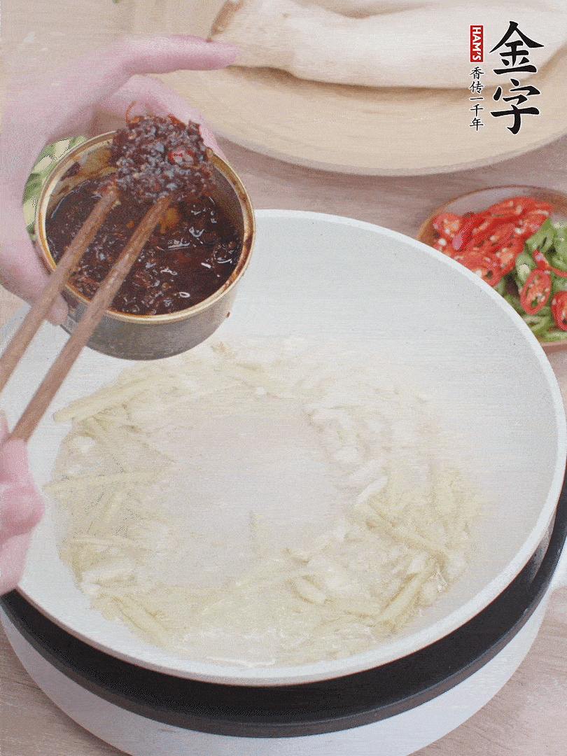 起鍋熱油，姜蒜、金字火腿干貝醬煸香。