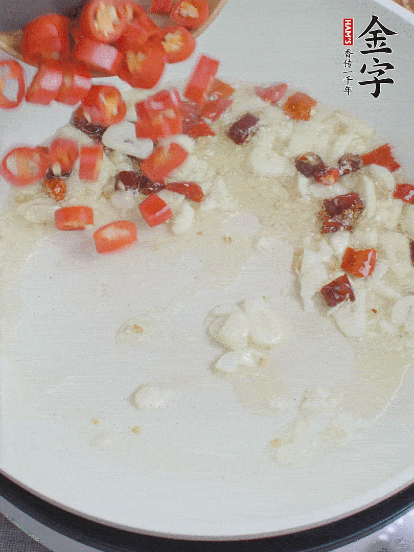 油6成熱，下蒜末、干紅辣椒煸炒，出香味后再放美人椒、香腸。