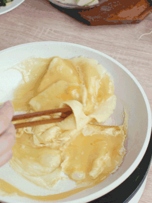 油6成熱時，下雞蛋液，邊緣凝固時翻拌成塊狀。