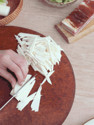 茭白切細(xì)絲，鹽水中浸泡防止氧化。