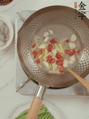 油7成熱時(shí)，下大蒜粒、姜絲、小米辣煸香。