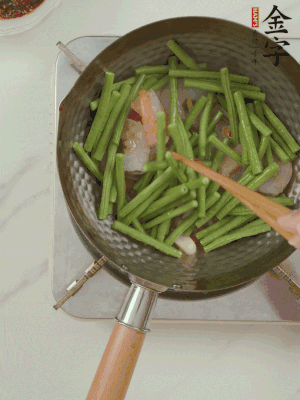 下掰好的缸豆段翻炒，略燜煮。