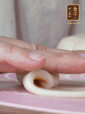 做面劑 油皮按扁，中間包入一個(gè)油酥，邊緣收緊捏死。包好的面劑按扁，用搟面杖搟壓成橢圓形。從底部向上卷成筒狀，用保鮮膜蓋好松弛15分鐘，再把筒狀縱向搟壓成長(zhǎng)條狀。再卷一次，松弛20分鐘