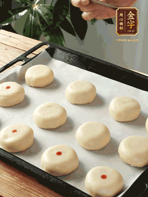 收口向下放在案板上，輕輕將月餅坯按扁，用筷子點(diǎn)紅點(diǎn)做裝飾