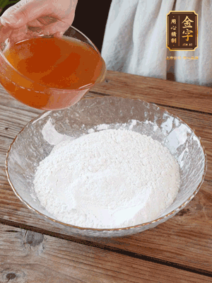 轉(zhuǎn)化糖漿、枧水、花生油攪拌均勻，加入面粉混合，醒發(fā)2小時。捏成23g一個的小球