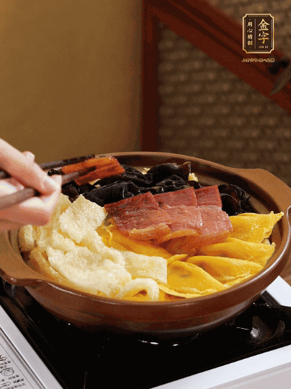 砂鍋底部鋪上娃娃菜，依次擺上肉皮、蛋餃、黑木耳、火腿